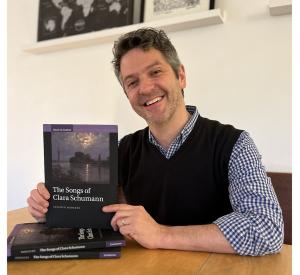 Stephen Rodgers, Professor and Edmund A. Cykler Chair in Music, holding the copy of his book, "The Songs of Clara Schumann"