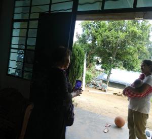 A chat with a Myanmar Jingo wife, who holds a baby on the left side / photo provided by Xiaobo Su