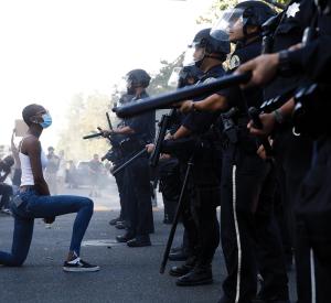 San Jose George Floyd Protests: A protester takes a knee in front of San Jose Police officers during a protest on East Santa Clara Street in San Jose, Calif., on May 29, 2020, after the death of George Floyd in Minneapolis. / Photo by Dai Sugano, MediaNews Group, The Mercury News via Getty Images