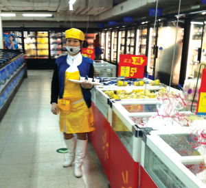 A migrant woman sells yogurt in a Beijing Walmart. She holds out free samples on her tray and wears a microphone over her face mask to announce the product and price to customers / photo by Eileen Otis.