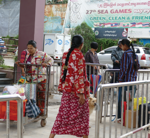 Several Burmese females working together to transfer commodities via the immigration checkpoint from Ruili to Muse. The background of the photo is the streetscape in Muse, a key commercial port between Myanmar and China / photographs by Xiaobo Su.