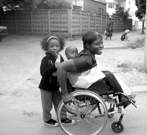 Irene Moyo, pictured here with her children, received a loan for her street vending business from research collaborating organization Zimbabwe Women with Disabilities in Development (ZWIDE).