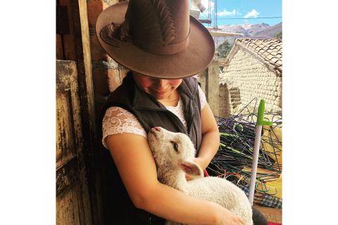Rosa at her home with a lamb from her flock / photo by H. Moulton.
