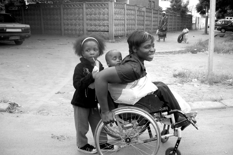 Irene Moyo, pictured here with her children, received a loan for her street vending business from research collaborating organization Zimbabwe Women with Disabilities in Development (ZWIDE).