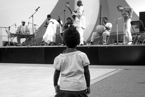A young girl watches the performance of musicians at a meeting of an association of immigrants from Mauritania, West Africa, in Paris, France.