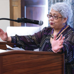 Sangita Gopal speaking at a podium.