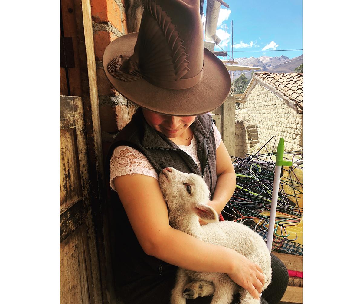 Rosa at her home with a lamb from her flock / photo by H. Moulton.