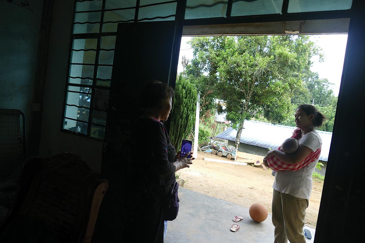 A chat with a Myanmar Jingo wife, who holds a baby on the left side / photo provided by Xiaobo Su