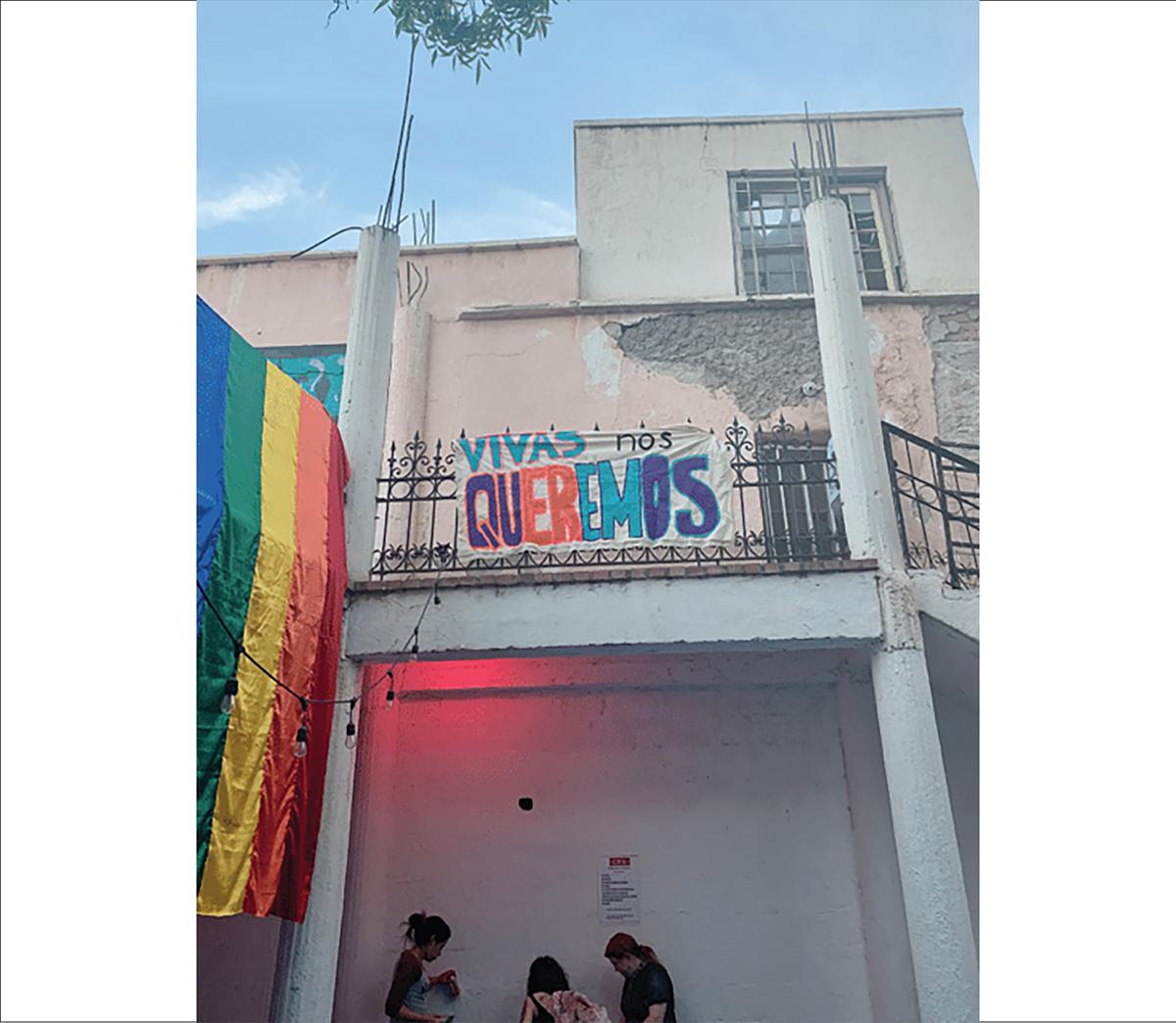 Beside the rainbow flag, a sign states "we want us alive." The image is from Polet's fieldwork, pre-pandemic / photo by Polet Campos-Melchor.