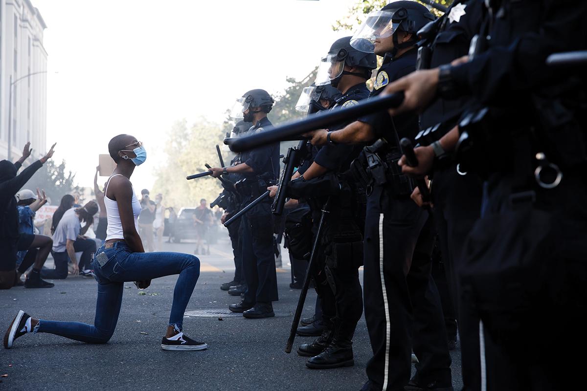 San Jose George Floyd Protests: A protester takes a knee in front of San Jose Police officers during a protest on East Santa Clara Street in San Jose, Calif., on May 29, 2020, after the death of George Floyd in Minneapolis. / Photo by Dai Sugano, MediaNews Group, The Mercury News via Getty Images