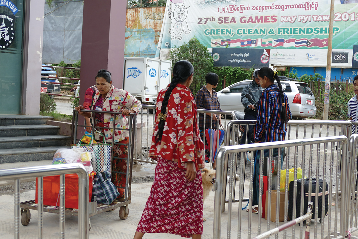 Several Burmese females working together to transfer commodities via the immigration checkpoint from Ruili to Muse. The background of the photo is the streetscape in Muse, a key commercial port between Myanmar and China / photographs by Xiaobo Su.