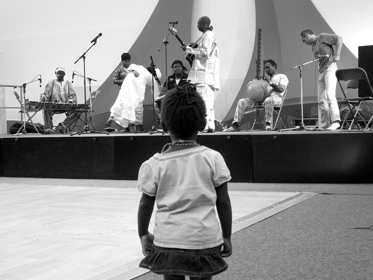 A young girl watches the performance of musicians at a meeting of an association of immigrants from Mauritania, West Africa, in Paris, France.