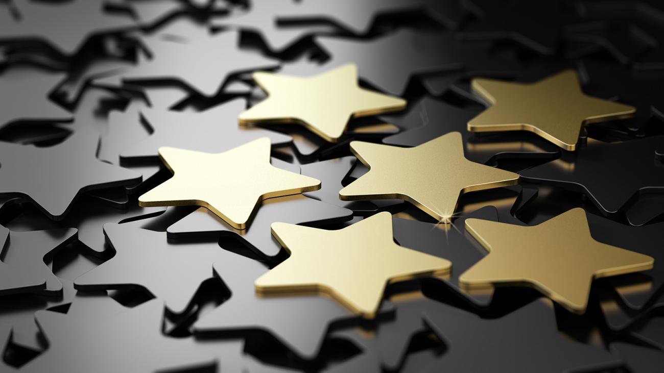 Six gold stars rest on a pile of other stars.