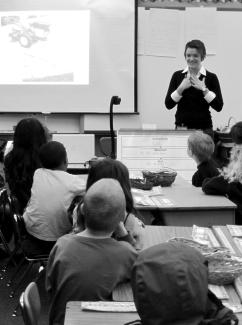 Philosophy graduate student Megan Burke talks about women’s roles in agriculture to a class of first graders at the 4J French Immersion school in south Eugene (photo by Alice Evans).